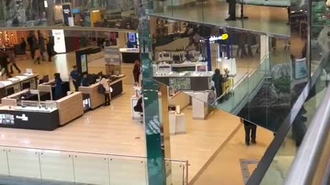 Two guys jump over railing mall into pool water