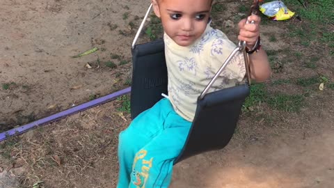 After a long time !! kid is playing on the swing without friends.