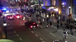 Police SUV runs through crowd crossing the street