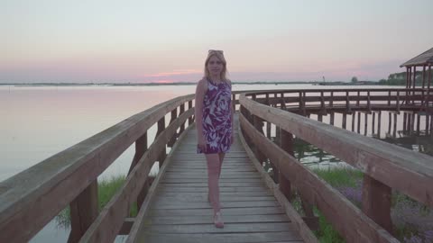 Attractive girl walking on the wood footbridge