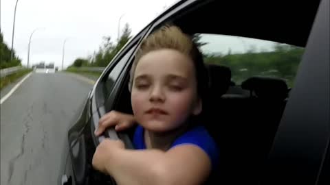 Kid driving with Wind in her face