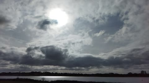 The flashing sun, from behind the clouds