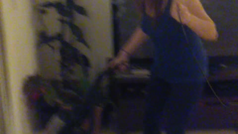 Woman Rides Electric Hoverboard While She Vacuums The House