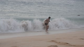 Man Runs Away While Woman Gets Hit By Wave