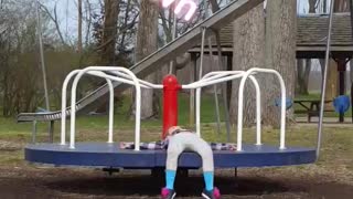 Little girl falls asleep on playground roundabout