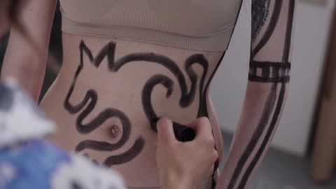 Artist Drawing a Cat on Model's Belly