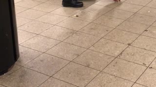 Man blue outfit scratching and tapping floor subway
