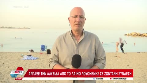Parasite robs an old lady of her necklace on a beach in Greece during a live TV report..