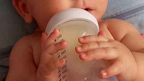 baby Timur drinks milk himself