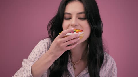 Girl eating a glazed donut with a milkshake