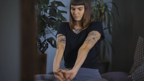 Young woman stretching her body sitting on the floor at home