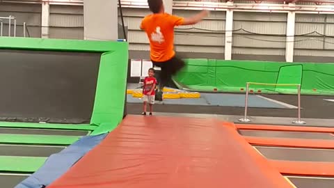 Guy in orange failed back flip in trampoline park