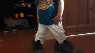 One year Old boy trying to use daddys shoes