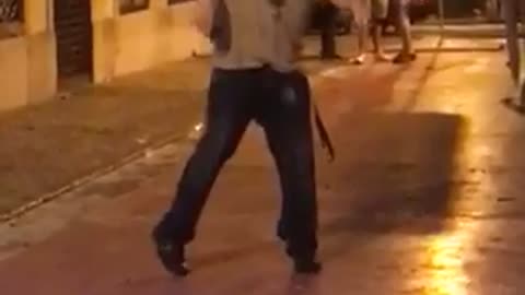 Music guy with black headphones on running around in circles in the street dancing