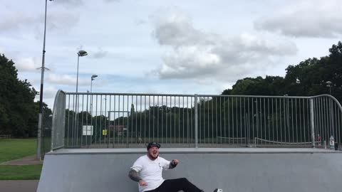 Big man white shirt falls on butt skateboard