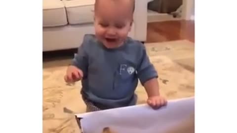 A Baby Reacting To His Gift