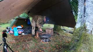 Cooking burgers and sausages under a tarp. On a portable firepit Sep 2022