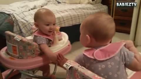Funny baby sees mirror for the first time