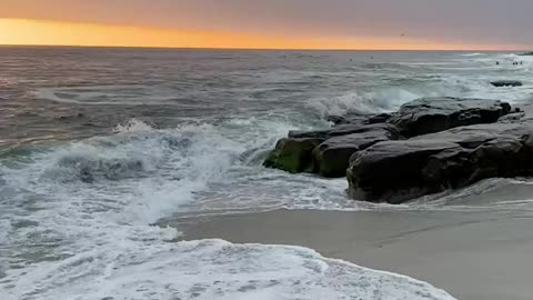 The sound of sea waves hitting the beach rocks.