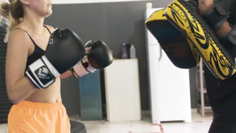 a woman punching and kicking a bag