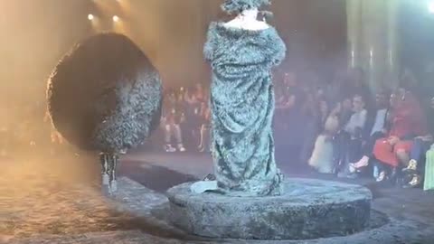 Sam Smith performs at Paris Fashion Week in bizarre furry blanket