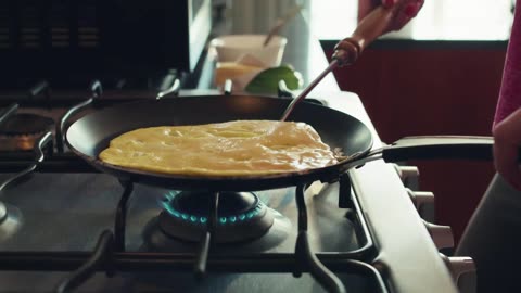 Woman flipping her egg omelet