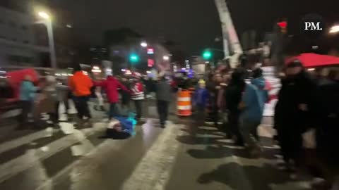 Freedom Rally Participants in Ottawa holding hands and singing “We Are the World” outside Parliament Hill