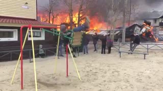 Boy enjoys and swings while home burns down