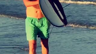 Surfer takes knee on beach