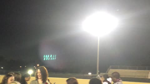 Ghostly wisps floats above gathering on football field