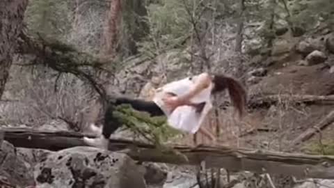 Teenage Girl Falls into a waterfall doing yoga on tree branch