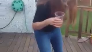 Red headed woman in torn jeans is drinking beer on skateboard and falls down on deck