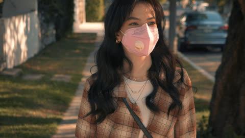 Woman with face mask walking with groceries