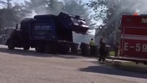 Garbage Truck Dumps Burning Load into Fire Station Parking Lot