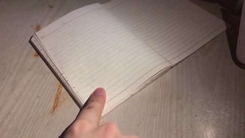 A mere human being tries to make a crack in a notepad with his finger.