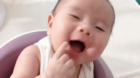 Smiling brightly baby boy sitting on a chair.