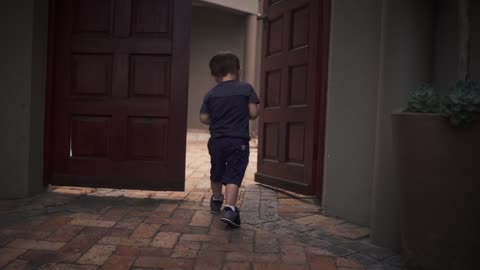 The boy is raising with a wooden door to open