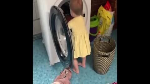 Precious baby helps her mom with the laundry