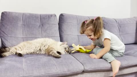 Adorable_Baby_Girl_Shares_Her_Banana_With_a_Cat