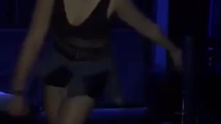 Girl in black dress dances to music at club