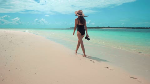 Woman in bikini walking on shore