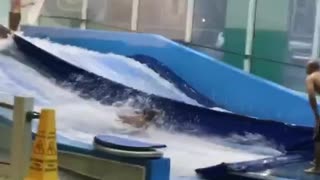 Yellow boogie board kid faceplants on wave machine indoors