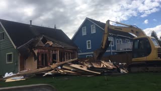 Excavator destroys house