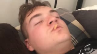 Sleeping guy eats french fry in bed