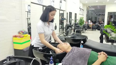Relaxing shampoo and massage with beautiful young girl in the men's hair system Manly