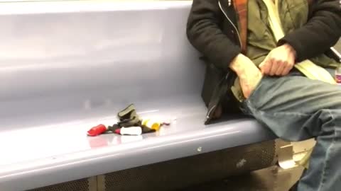 Old man empties his pockets and puts pills on subway seat