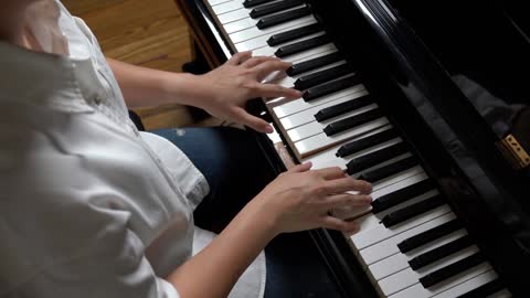 young woman playing piano learning to play piano taking piano lessons