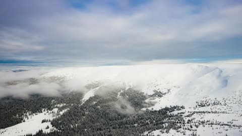 Revealing a snowy mountain from the cloudy sky