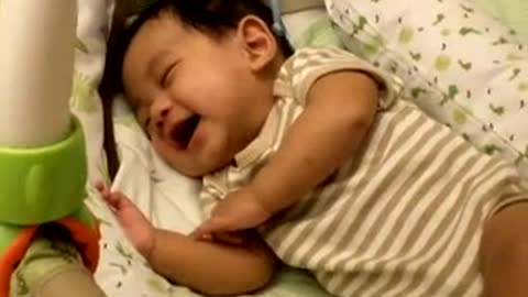 Adorable baby laughing while sleeping