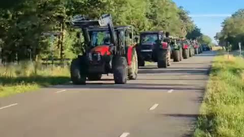 Dutch and German farmers exchange flags at the border before working in tandem